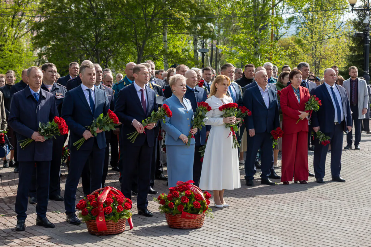 Участники памятной церемонии в Южно-Сахалинске с цветами у мемориала жертвам Нефтегорского землетрясения
